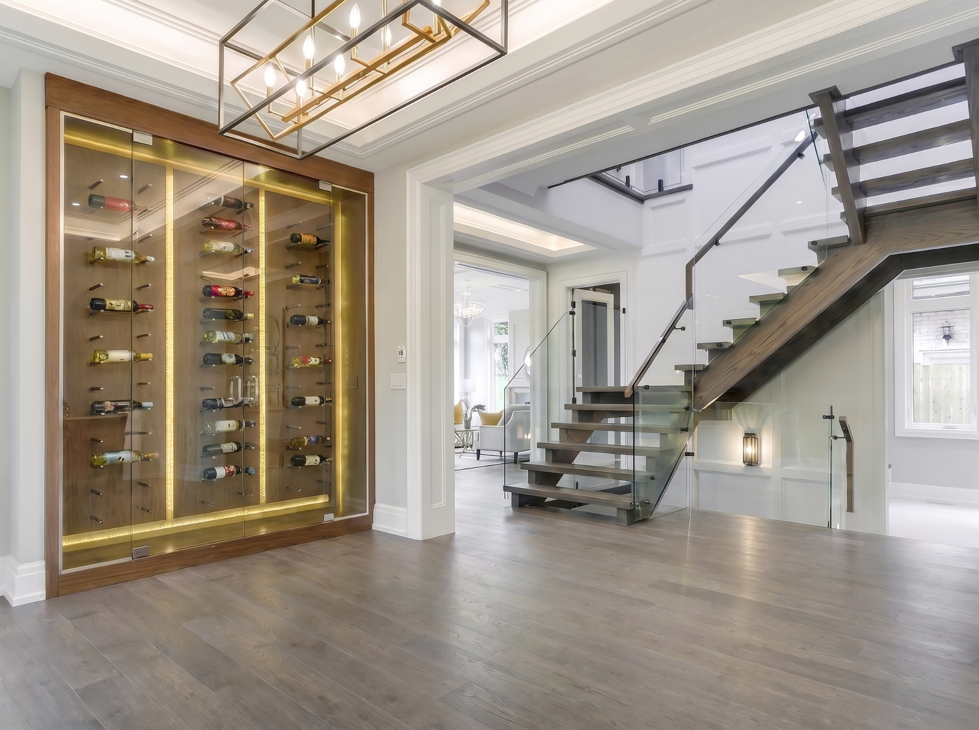 Climate-controlled custom wine cellar with glass display walls and dark millwork